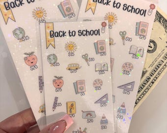 May include: Three sheets of stickers with a back to school theme. Each sheet has various images of school supplies, including a globe, a pencil, a book, a backpack, a ruler, a pair of scissors, and a peach. Each image has a price listed next to it. The total price for all the stickers is $300.