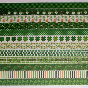 May include: A collection of decorative adhesive tapes featuring St. Patrick's Day themes, including patterns of gnomes, beer mugs, shamrocks, rainbows, and plaid designs in various shades of green, white, and orange with text.