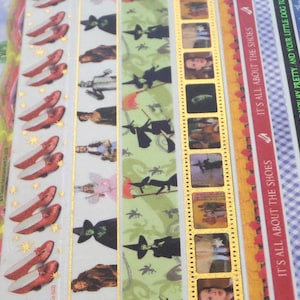 May include: A set of seven washi tapes featuring a Wizard of Oz theme. The tapes feature images of ruby slippers, the Wicked Witch of the West, the Yellow Brick Road, and film strips with scenes from the movie. The text on the tapes includes quotes from the movie, such as "It's all about the shoes" and "I'll get you my pretty, and your little dog too."