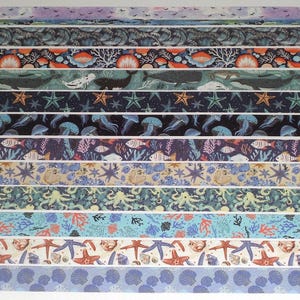 May include: A collection of decorative washi tapes featuring various marine life patterns. Designs include starfish, jellyfish, whales, and coral in shades of blue, orange, and purple. The tapes are arranged in horizontal rows.