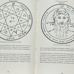 May include: An open book displaying two black and white illustrations of mystical symbols and text. The left page shows a star-shaped diagram with Hebrew text. The right page features a bearded figure within a circular design.