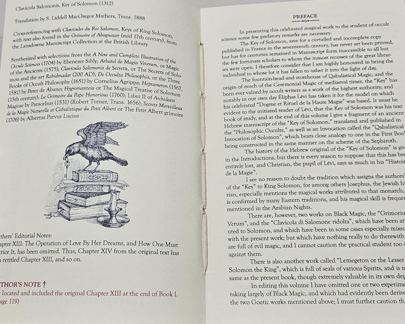 May include: A vintage book, open to reveal text and an illustration of a bird atop a pile of books. The title "Clavicula Salomonis, Key of Solomon" is displayed. The pages are aged, with a preface on the right-hand page.