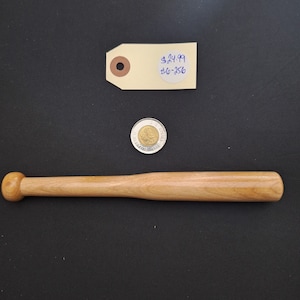 May include: A wooden baseball bat with a rounded end. The bat is approximately 38 cm long and is made of light brown wood. A price tag is visible in the image with the text "$24.99 116-356".