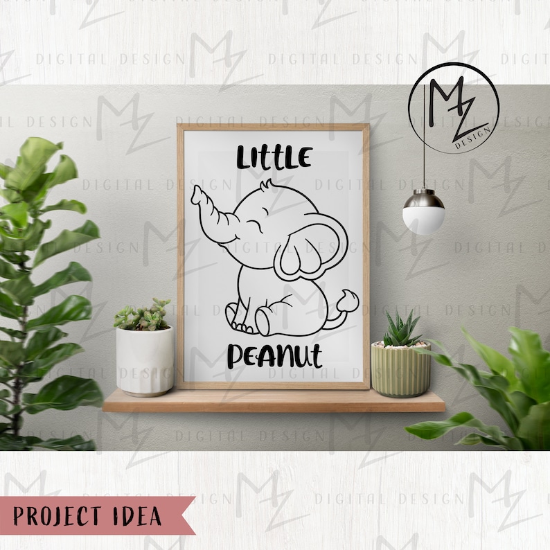 May include: A black and white illustration of a smiling elephant with the text "Little Peanut" on a white background. The illustration is framed and hanging on a wall.
