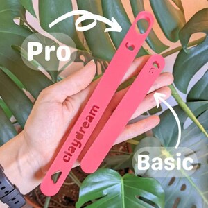 May include: Two pink silicone phone straps, one labeled "Pro" and the other "Basic". The "Pro" strap has the text "claydream" printed on it.