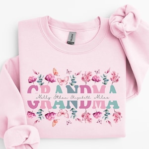 Plantilla personalizable de abuela con flores rosas en formato PNG para los nombres de los nietos. Camiseta de cumpleaños de abuela con mariposas. Camiseta personalizada con nombre dividido para el día de la madre en formato PNG