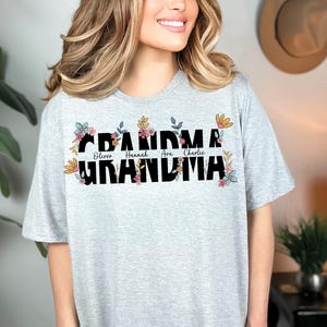 May include: A gray t-shirt with a floral design and the text "Grandma" with the names "Oliver, Hannah, Ava, Charlie" printed below.