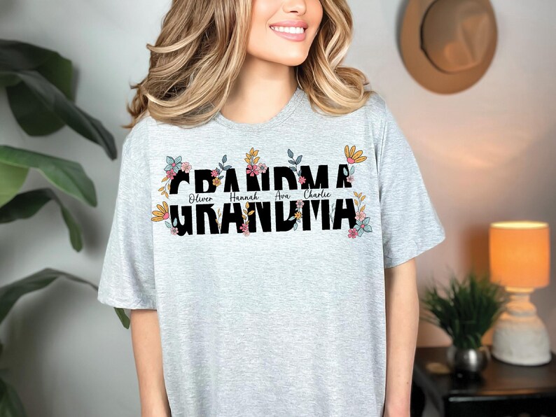 May include: A gray t-shirt with a floral design and the text "Grandma" with the names "Oliver, Hannah, Ava, Charlie" printed below.