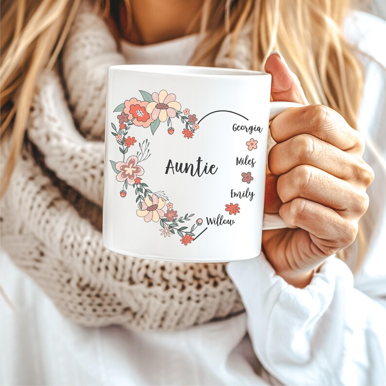 Pode incluir: Caneca de cer&acirc;mica branca com um design de cora&ccedil;&atilde;o floral. O cora&ccedil;&atilde;o diz "Tia" e lista os nomes Georgia, Miles, Emily e Willow.