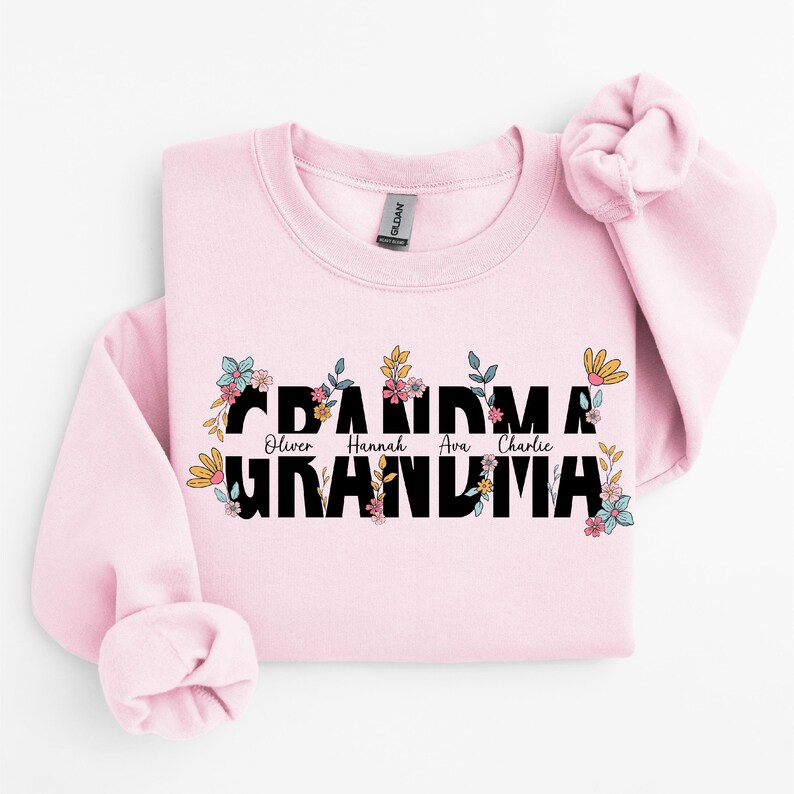 May include: Pink sweatshirt with a floral design and the text "Grandma" with the names "Oliver, Hannah, Ava, Charlie" printed above the word "Grandma".