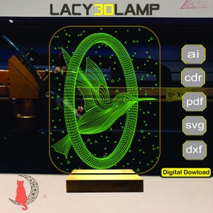 May include: A green line art design of a hummingbird flying inside a circular frame. The design is on a clear acrylic panel with a wooden base. The image includes the text "LACY3DLAMP" and "Digital Dowload".
