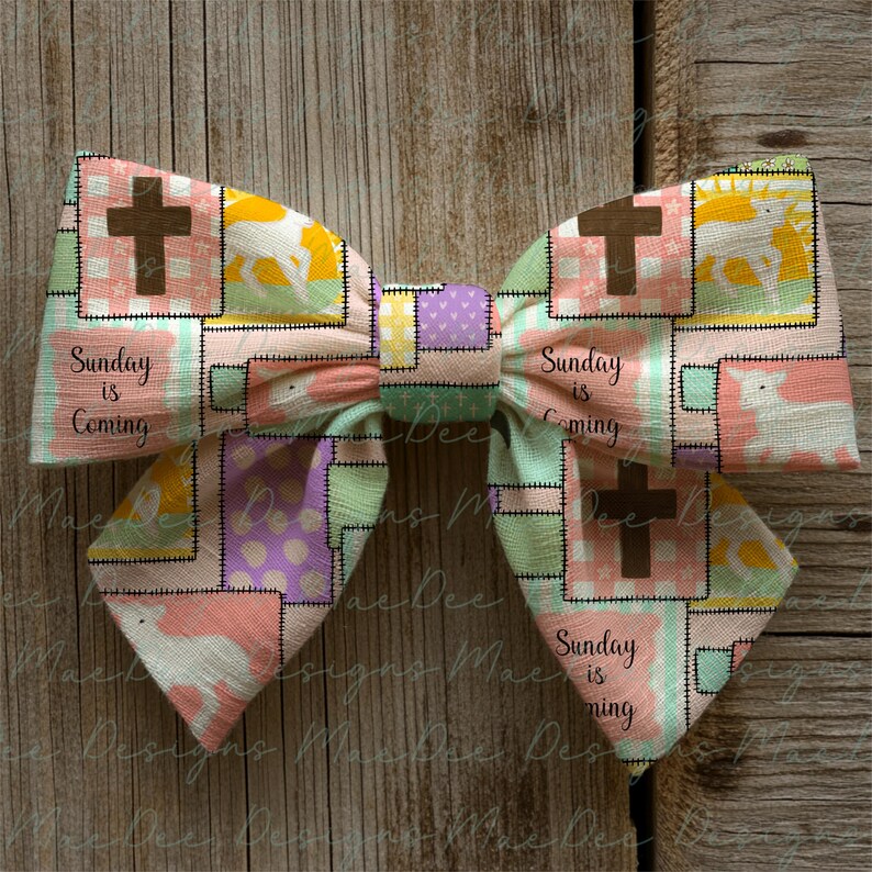 Może przedstawiać: Ręcznie robiona kokarda z patchworkowym wzorem. Zawiera krzyże, pastelowe kolory i napis "Sunday is Coming". Kokarda jest ozdobnym dodatkiem z centralnym węzłem.