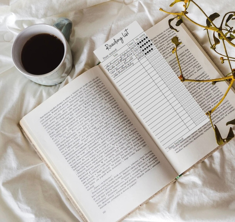 May include: A close-up of an open book with a reading list on the right page. The list includes the titles "The Prisoner of Azkaban", "Pride and Prejudice", "The Great Gatsby", and "The Secret History". The list also includes columns for the date started, date finished, and a rating system with five stars.