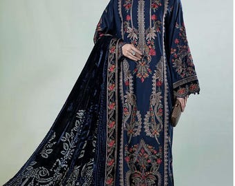 Könnte beinhalten: Ein dunkelblaues, langärmeliges Kleid mit aufwendigen Blumenstickereien in Gold- und Rotfaden. Das Kleid hat einen passenden Dupatta mit einem Samtbesatz und Blumenmustern. Der Dupatta ist über die Schulter der Frau gelegt.