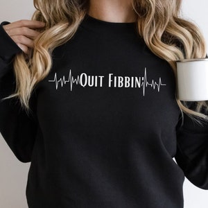 May include: Black sweatshirt with a white heartbeat graphic and the text "QUIT FIBBIN".