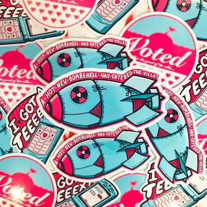 May include: A die-cut sticker featuring a light blue bomb-shaped graphic with pink accents and a heart icon. The text A HOT NEW BOMBSHELL HAS ENTERED THE VILLA is printed in a circular arc around the top of the bomb illustration.