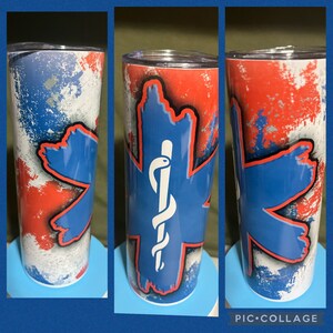 May include: A stainless steel tumbler with a red, white, and blue design. The design features a blue star of life with a white medical caduceus symbol in the center. The tumbler is perfect for holding hot or cold beverages.