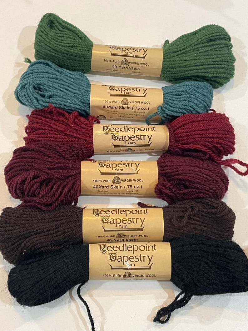 May include: Six skeins of 100% pure virgin wool tapestry yarn in various colors, including green, teal, burgundy, brown, and black. Each skein is labeled "Needlepoint Tapestry Yarn" and includes the text "40-Yard Skein (.75 oz.)".