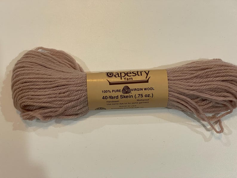 May include: A skein of Tapestry Yarn in a muted rose color. The label reads "100% Pure Virgin Wool, 40-Yard Skein (.75 oz.)". The yarn is hand dyed and mothproof. Ideal for knitting and crochet projects.