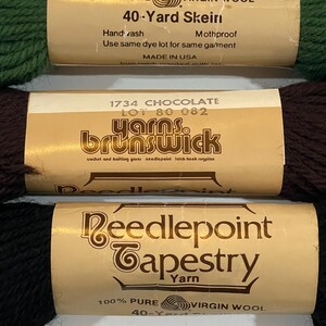May include: Three skeins of 100% pure virgin wool yarn. The skeins are labeled "40-Yard Skein", "yarns. brunswick", and "Reedlepoint Tapestry Yarn".