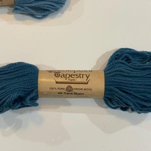 May include: A skein of teal-colored Needlepoint Tapestry Yarn, made of 100% pure virgin wool. The label reads "40-Yard Skein". The yarn is a vibrant teal color, perfect for various crafting projects.