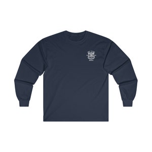 May include: A navy blue long-sleeve t-shirt with a white embroidered patch featuring the text "Fort Apache", "NY", "N.Y.P.D." and "Bronx".