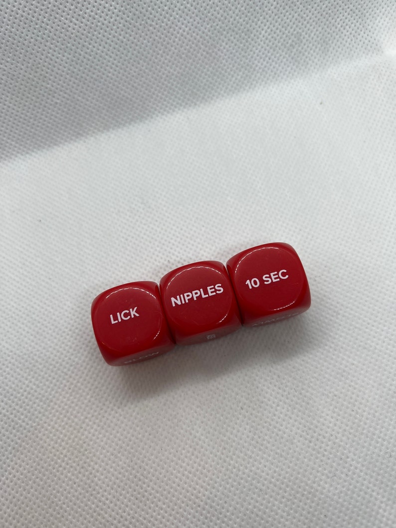 May include: Three red dice with white lettering. The dice read "LICK", "NIPPLES", and "10 SEC".