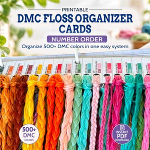 Op de afbeelding: Printbare DMC-borduurgaren-organizerkaarten met een systeem om 500+ DMC-kleuren op nummer te sorteren. De kaarten worden bij elkaar gehouden door witte ringen, met diverse gekleurde borduurgarens bevestigd aan elke kaart, gelabeld met kleurnummers.