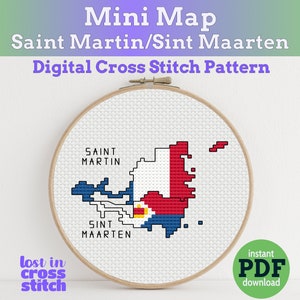 May include: A cross-stitch pattern of the Saint Martin/Sint Maarten map, displayed in a wooden embroidery hoop. The map is rendered in white, blue, and red, with text reading "SAINT MARTIN" and "SINT MAARTEN". The text "Mini Map" and "Digital Cross Stitch Pattern" are also visible.