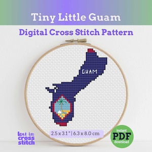 May include: A cross-stitch pattern of Guam, displayed in a wooden embroidery hoop. The design features a navy blue outline of the island with a detailed emblem. The text "Tiny Little Guam" and "Digital Cross Stitch Pattern" are visible. The pattern measures 2.5 x 3.1 inches.
