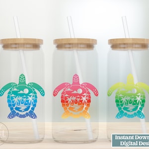May include: Three clear glass tumblers with bamboo lids and white straws. Each tumbler features a colorful silhouette of a sea turtle with palm trees and a sunset inside the shell. The tumblers are on a wooden surface.