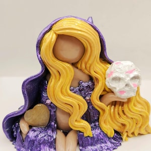 3.Blonde yellow long hair witch with lavender light purple witch hat and cape holding a skull with kisses all over. Yellow jade heart
