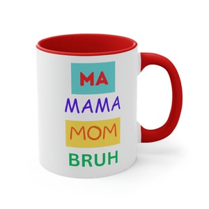 May include: White ceramic mug with a red rim and handle. The mug has the words "MA MAMA MOM BRUH" printed on it in colorful boxes.