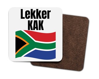 May include: A white coaster featuring the South African flag and the text "Lekker Kak" in black.