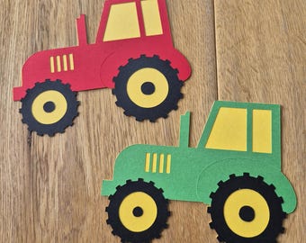May include: Two colorful tractor cutouts. One is red with yellow and black accents, and the other is green with yellow and black accents. The tractors have large wheels and are set against a wooden background.