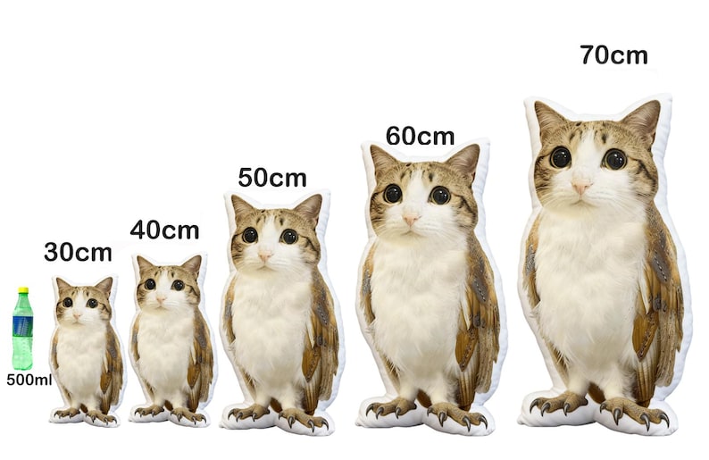 May include: A collection of cat-shaped plush pillows in various sizes, ranging from 30cm to 70cm tall. The pillows feature a realistic cat design with brown and white fur, large eyes, and a standing pose. A 500ml bottle is included for size comparison.
