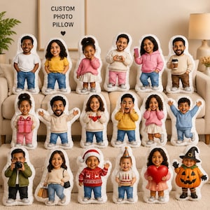 Pode incluir: Uma coleção de almofadas com fotos personalizadas em formato de pessoas, apresentando vários indivíduos em diferentes trajes, incluindo temas festivos, segurando itens como presentes, câmeras e corações, exibidos em um sofá.