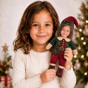 May include: A plush doll featuring a custom photo face of a child with brown hair. The doll wears a dark green jacket with holly berry embroidery, a brown belt with a gold buckle, dark red trousers, and matching dark red lace-up boots.