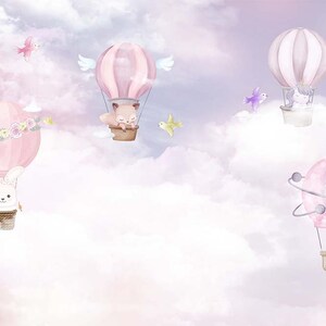 K&ouml;nnte beinhalten: Aquarellillustration von rosa Hei&szlig;luftballons mit niedlichen Tierfiguren, darunter ein Hase, ein Fuchs und ein Einhorn, die in einem vertr&auml;umten, wolkenverhangenen Himmel schweben. Die Ballons haben Blumen- und Fl&uuml;gelakzente.