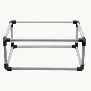 May include: A white metal frame with black corner connectors. The frame is rectangular and appears to be a support structure or a component of a larger item. The design is simple and functional, with clean lines and a minimalist aesthetic.
