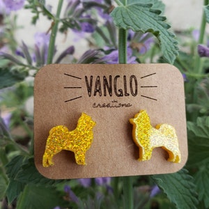 May include: A pair of yellow glitter dog silhouette earrings on a brown card with the text "VANGLO by creations".