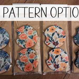 May include: Eight round, floral patterned coasters in various colors, including blue, white, orange, and green. The coasters are packaged in clear plastic and labeled "Cup Coaster" with the text "37 Pattern Options".