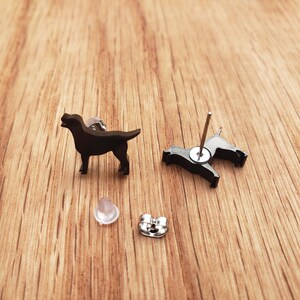 May include: A pair of black dog silhouette stud earrings. The earrings are made of metal and have a post back.