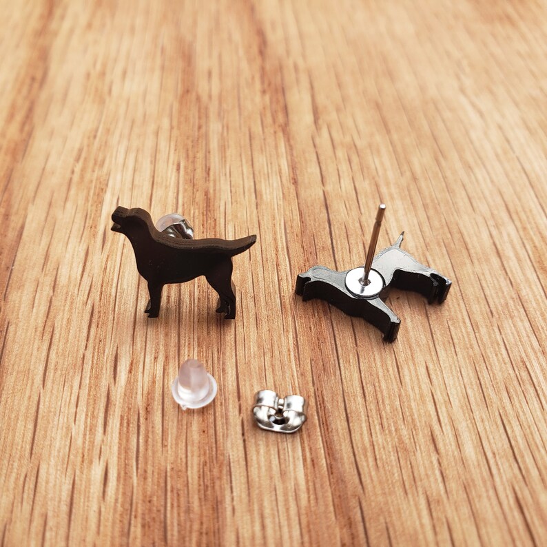 May include: A pair of black dog silhouette stud earrings. The earrings are made of metal and have a post back.