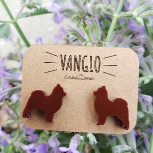 May include: A pair of brown dog silhouette earrings on a card that says "Vanglo Creations".