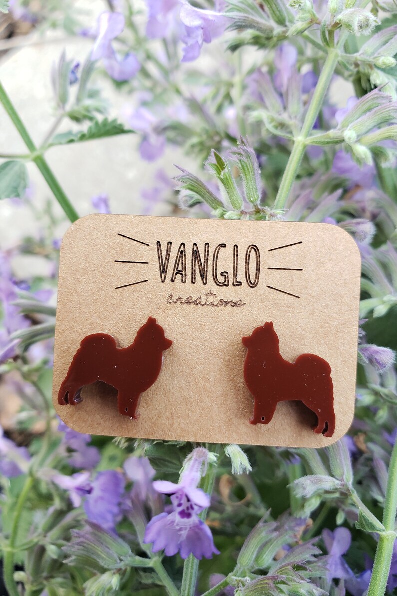 May include: A pair of brown dog silhouette earrings on a card that says "Vanglo Creations".