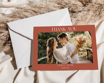 May include: A thank you card featuring a photograph of a couple embracing. The card is red with white text that reads "Thank You" and "Laura & Jacob 30.07.XX".