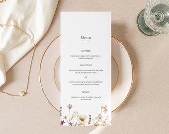 May include: A wedding menu card with a floral design. The menu includes appetizer, main course, and dessert options. The text on the card reads: "Menu", "Appetizer", "Mixed green salad with a raspberry infused vinaigrette", "Main Course", "Herb marinated rump steak with bernaise sauce and parmesan fries", "OR", "Salmon broiled and seasoned with bread crumbs, garlic, lemon and butter", "Dessert", "Raspberry white chocolate cake and assorted tea."