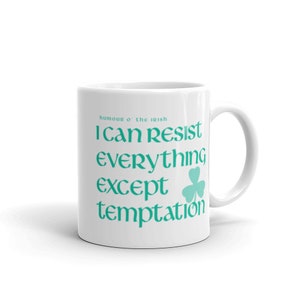 Puede incluir: Taza de cerámica blanca con un trébol verde turquesa y el texto "humour o' the irish I can resist everything except temptation".
