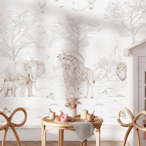 Può includere: Una scena di cameretta con un murale raffigurante animali della savana, come elefanti, giraffe e un leone, in una palette di colori neutri. Il murale presenta anche mongolfiere e alberi. Due sedie in rattan e un tavolino con snack completano la scena.